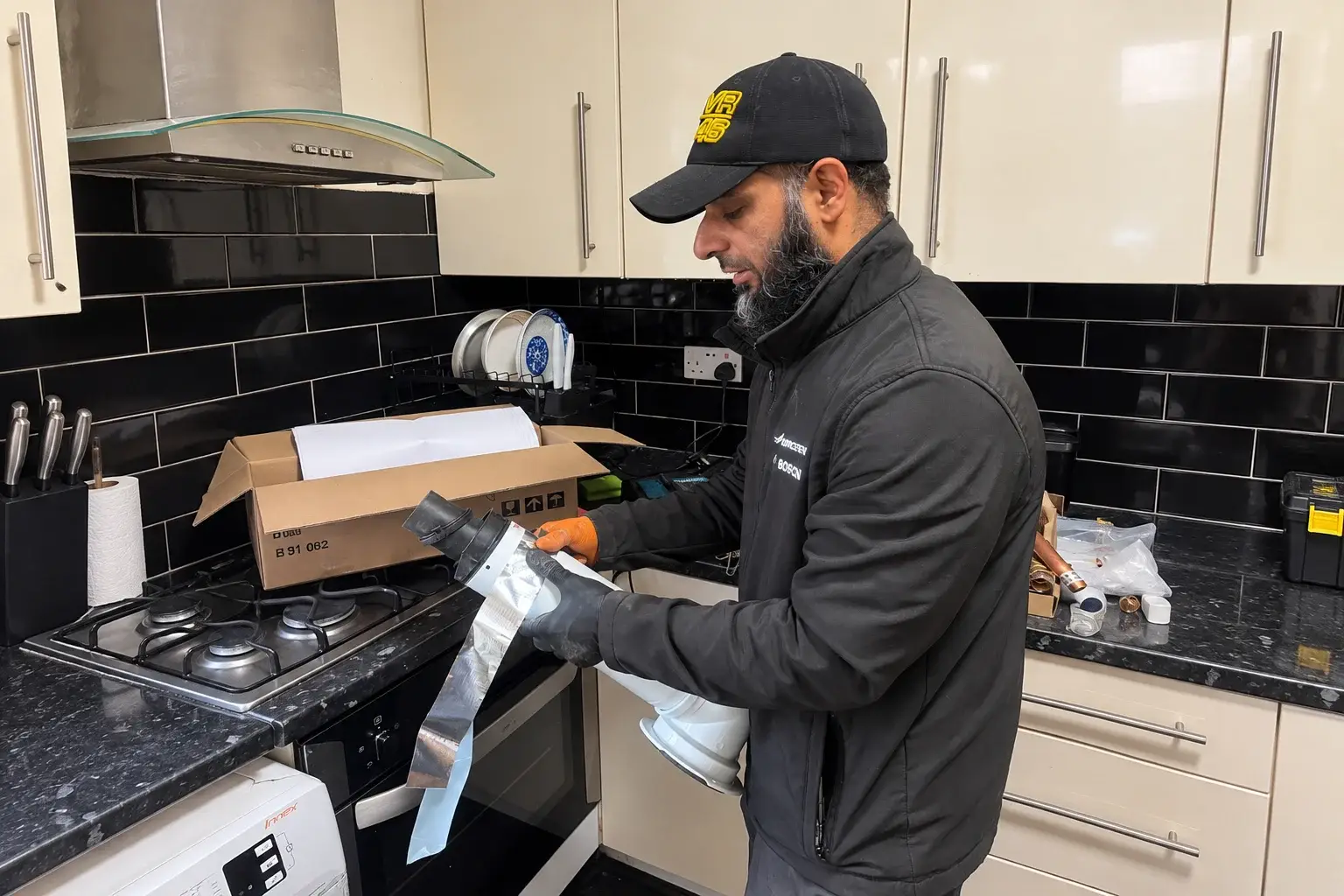Kitchen-Technician-Inspecting-Taped-Pipe-Component